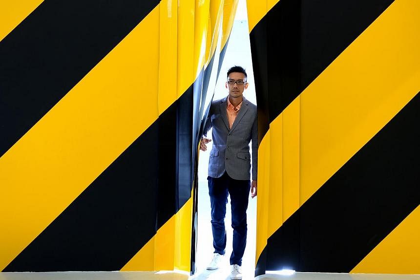Artist Michael Lee uses the black and yellow diagonal stripes of barricade tapes to signal a danger zone in Diagonals. -- ST PHOTO: JAMIE KOH