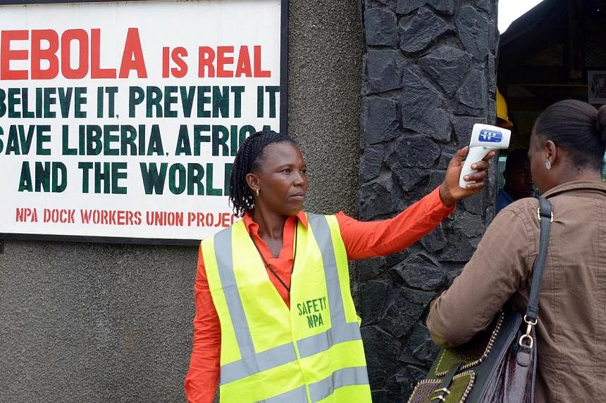 A security agent controls the temperature of a woman at the entrance of the port of Monrovia on Aug 29, 2014.&nbsp;An outbreak of the Ebola virus in the Democratic Republic of Congo has killed 31 people and the epidemic remains contained within the c