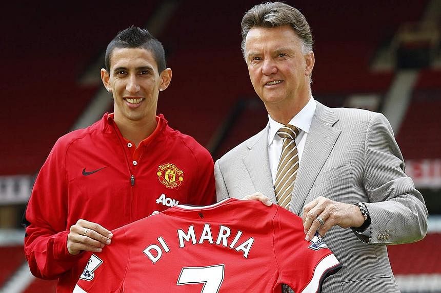 Manchester United's new signing Angel Di Maria (left) poses for a photograph with his shirt and with manager Louis van Gaal at Old Trafford in Manchester, northern England on Aug 28, 2014. -- PHOTO: REUTERS