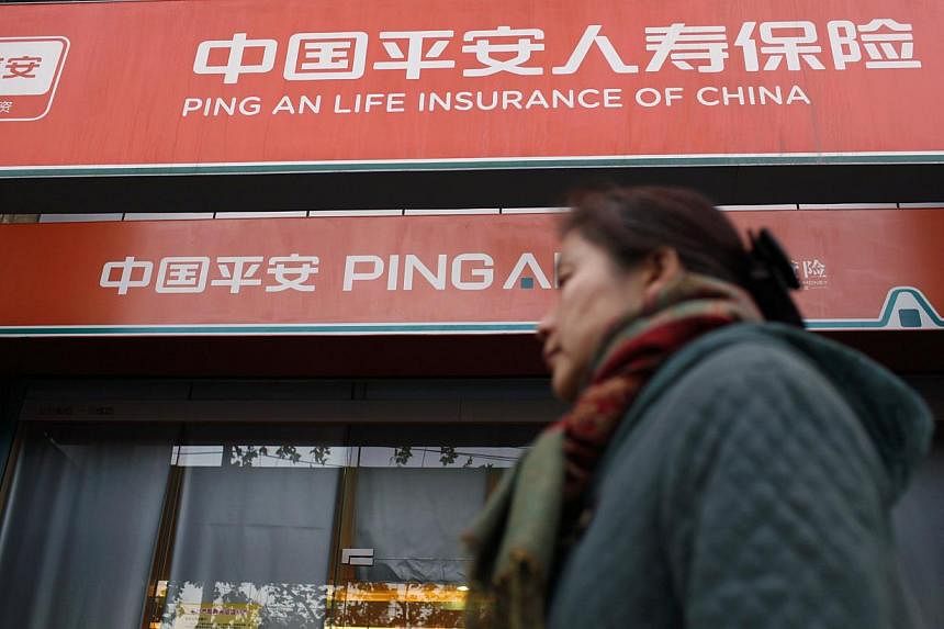 A woman walks past a Ping An Insurance building in Shanghai in this December 6, 2012 file photo. Ping An is among 23 Chinese insurance firms said by authorities on Tuesday to have colluded to fix fees. The companies were slapped with a total of 110 m
