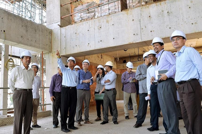 Minister-in-Charge of Muslim Affairs&nbsp;Dr Yaacob Ibrahim (middle, pointing upwards) visiting the Al-Ansar Mosque work site in Bedok on Sept 2, 2014 to view the latest construction work being done. -- PHOTO: BERITA HARIAN
