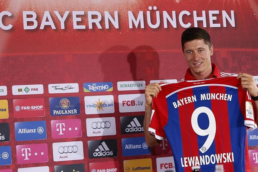 New Bayern Munich soccer player, Polish striker Robert Lewandowski, presents his new jersey during a news conference at Bayern Munich's headquarters in Munich on July 9, 2014. -- PHOTO: REUTERS