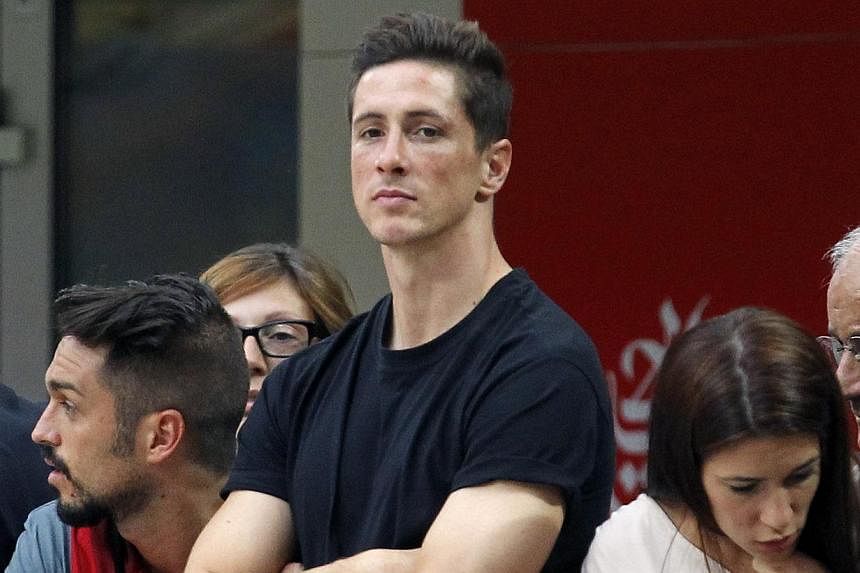 AC Milan's newly signed player Fernando Torres (centre) watches their Italian Serie A soccer match against Lazio at the San Siro stadium in Milan on Aug 31, 2014. -- PHOTO: REUTERS
