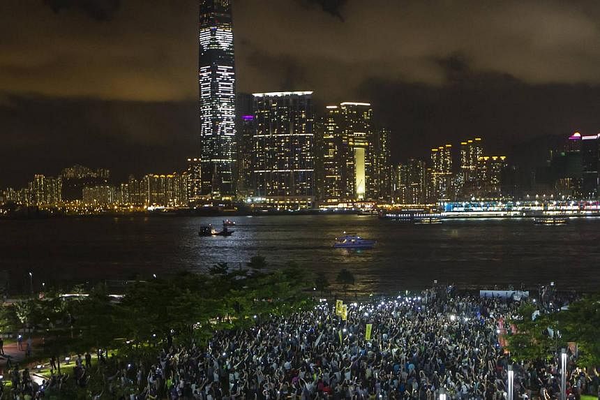 Pro-democracy protesters hold up their mobile phones during a campaign to kick off the Occupy Central civil disobedience event in Hong Kong, on Aug 31, 2014. -- PHOTO: REUTERS