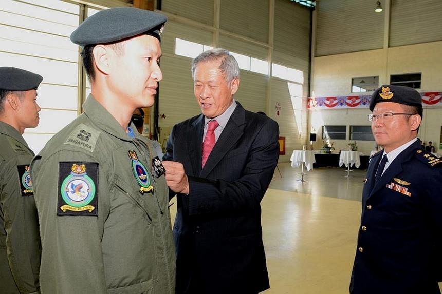 Dr Ng putting the M-346 aircraft patch on Commanding Officer of 150 Squadron, Lieutenant-Colonel Kelvin Wan.&nbsp;-- PHOTO: MINDEF