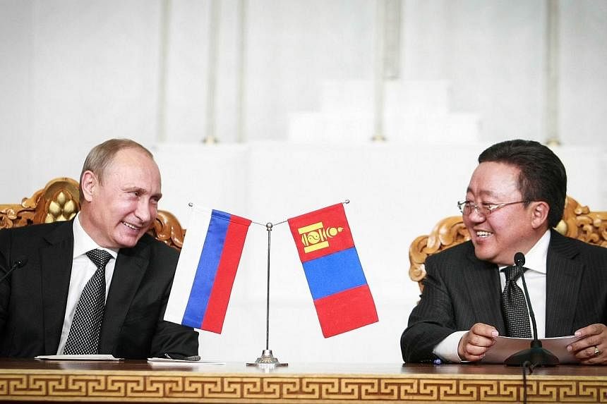 Russian President Vladimir Putin (left) smiles with Mongolian President Tsakhia Elbegdorj during a meeting in the Mongolian capital Ulan Bator on Sept 3, 2014.&nbsp;Russia's President Vladimir Putin on Wednesday unveiled a seven-point plan for peace 