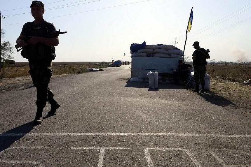 Ukrainian fighters from the Azov Battalion stand guard at a checkpoint on the outskirts of Mariupol on Sept 2, 2014.&nbsp;Russian President Vladimir Putin and his Ukrainian counterpart Petro Poroshenko have agreed to a "permanent ceasefire" in fighti