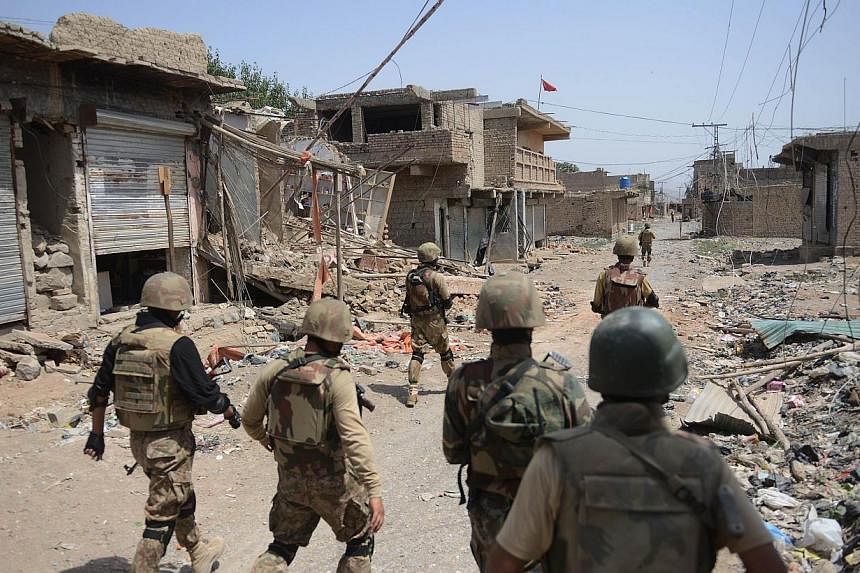 Pakistani soldiers patrol beside destroyed houses during a military operation against Taleban militants in the main town of Miranshah in North Waziristan on July 9, 2014.&nbsp;Pakistan's military said on Wednesday, Sept 3, 2014, it had killed more th