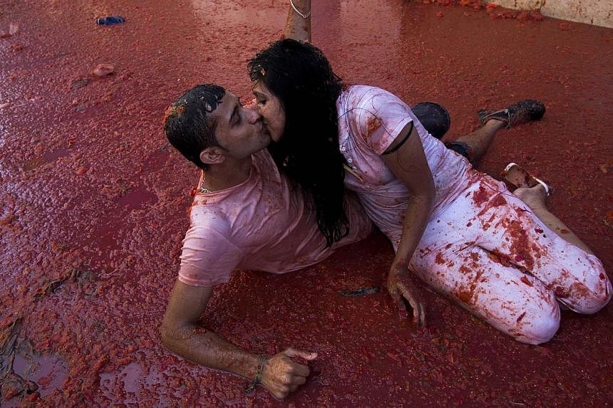 A couple kisses during the annual "tomatina" festivities in the village of Bunol, near Valencia on Aug 28, 2013.&nbsp;Two thousand tomato-wielding protesters are to stage a massive food fight in Amsterdam to protest Russia's ban on the import of Dutc