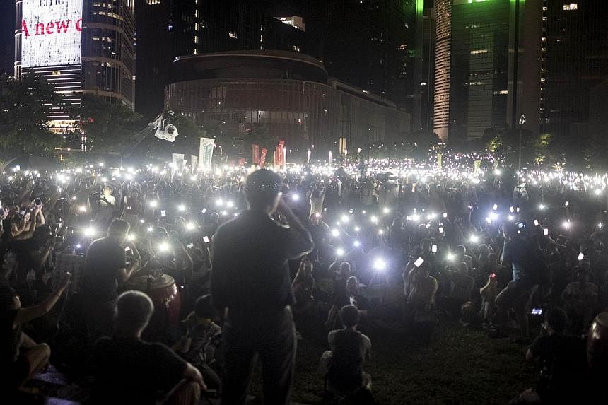Protesters wave their mobile phones and other electronic devices as they take part in a pro-democracy rally next to the Hong Kong government complex on Aug 31, 2014.&nbsp;China stressed on Wednesday that it would tolerate no foreign interference in H