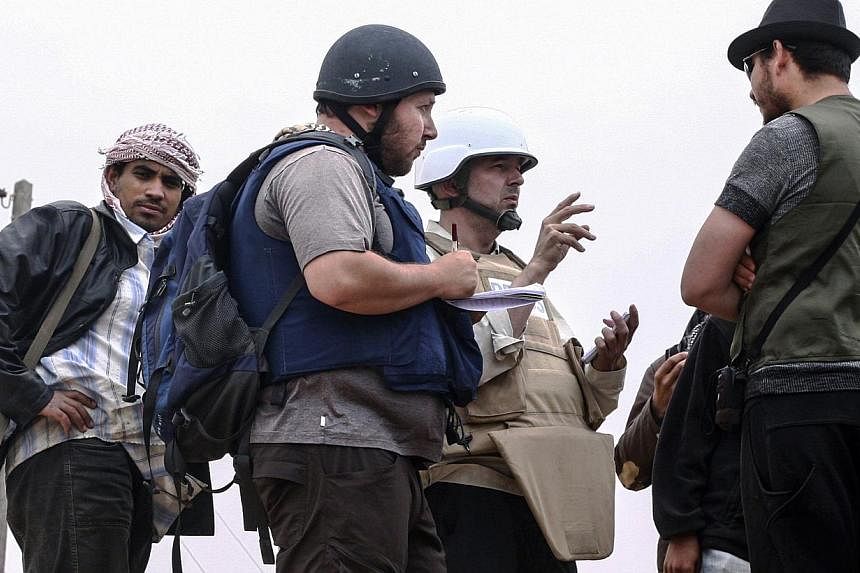 In this handout image made available by the photographer American journalist Steven Sotloff (centre with black helmet) talks to Libyan rebels on the Al Dafniya front line, 25 km west of Misrata on June 2, 2011 in Misrata, Libya. Mr Sotloff was kidnap