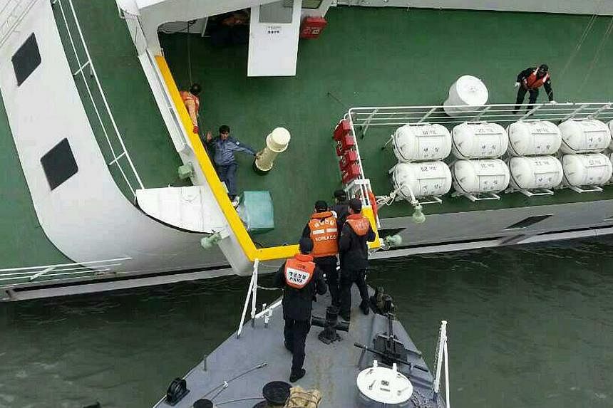 South Korea Coast Guard members rescuing some of the passengers and crew aboard the South Korean ferry Sewol on April 16, 2014. -- PHOTO: AFP