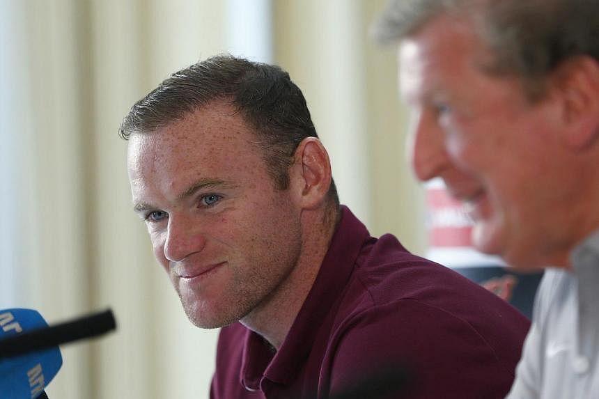 England captain Wayne Rooney (left) listens to manager Roy Hodgson during a news conference at their team hotel in Watford, north of London, Sept 2, 2014. -- PHOTO: REUTERS