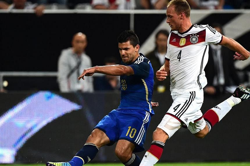 Argentina's striker Sergio Aguero (left) vies with Germany's defender Benedikt Howedes during a friendly football match between Germany vs Argentina in Duesseldorf, Germany, on Sept 3, 2014. -- PHOTO: AFP
