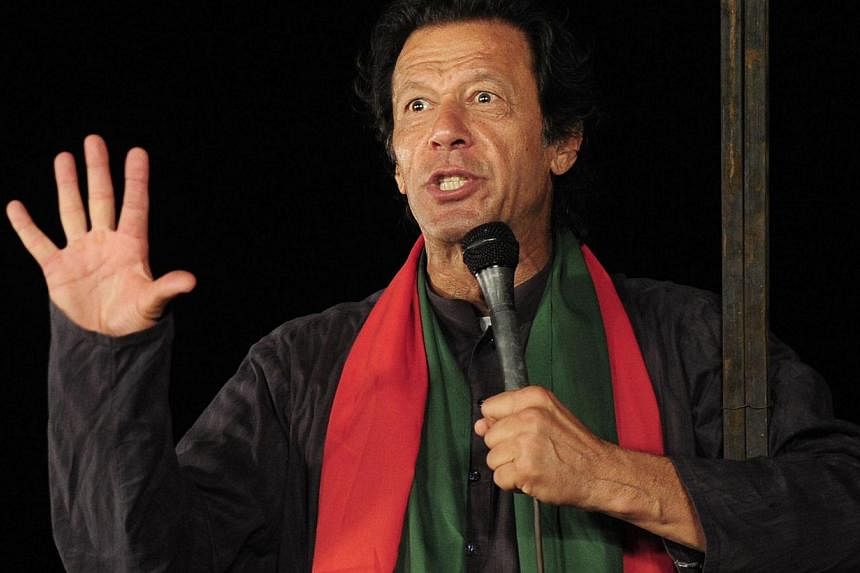 Pakistani cricketer-turned politician Imran Khan talks to supporters during an anti-government protest near the prime minister's residence in Islamabad on Sept 3, 2014. -- PHOTO: AFP