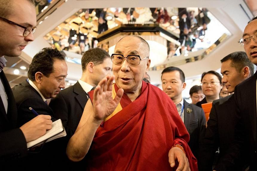 Tibetan spiritual leader Dalai Lama (middle) talks with journalists as he attends a Sino-Tibetan conference in Hamburg, northern Germany on Aug 27, 2014.-- PHOTO: AFP