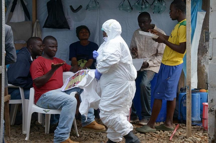 A health care worker of the John Fitzgerald Kennedy hospital of Monrovia wears a protective suit before going to the high-risk area of the hospital, the surgical section where Ebola patients are being treated. -- PHOTO: AFP