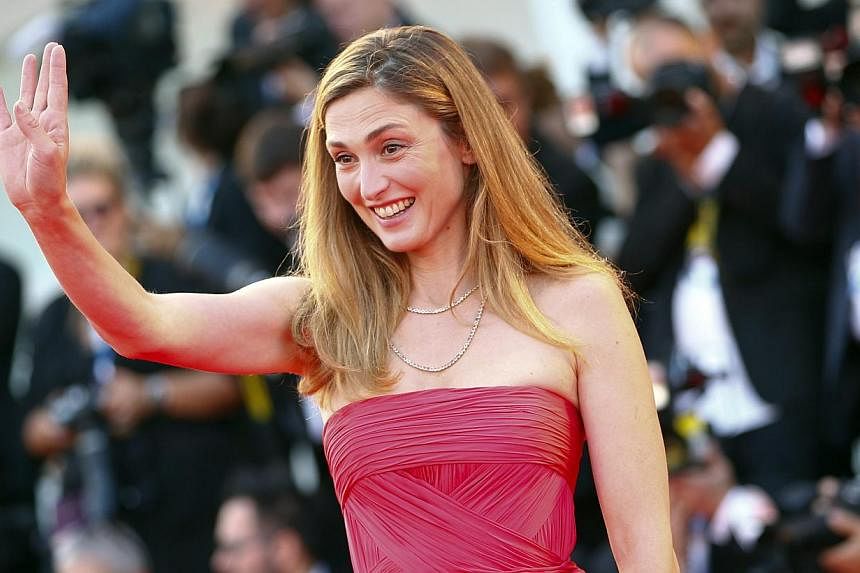 Actress Julie Gayet gestures as she arrives on the red carpet for the opening ceremony of the 71st Venice Film Festival in Venice Aug 27, 2014. -- PHOTO: REUTERS