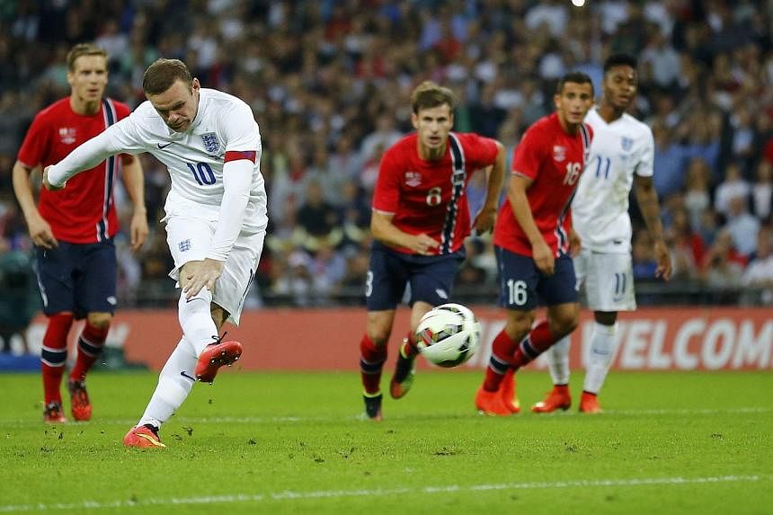 England captain Wayne Rooney shoots and scores his penalty during their international friendly match against Norway at Wembley Stadium in London on Sept 3, 2014. -- PHOTO: REUTERS