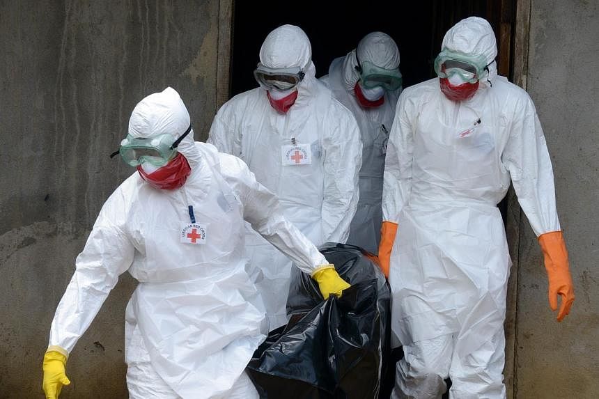 Medical workers of the Liberian Red Cross, wearing a protective suit, carry the body of a victim of the Ebola virus in a bag on Sept 4, 2014 in the small city of Banjol, 30km of Monrovia. The European Union promised 140 million euros (S$227 million) 