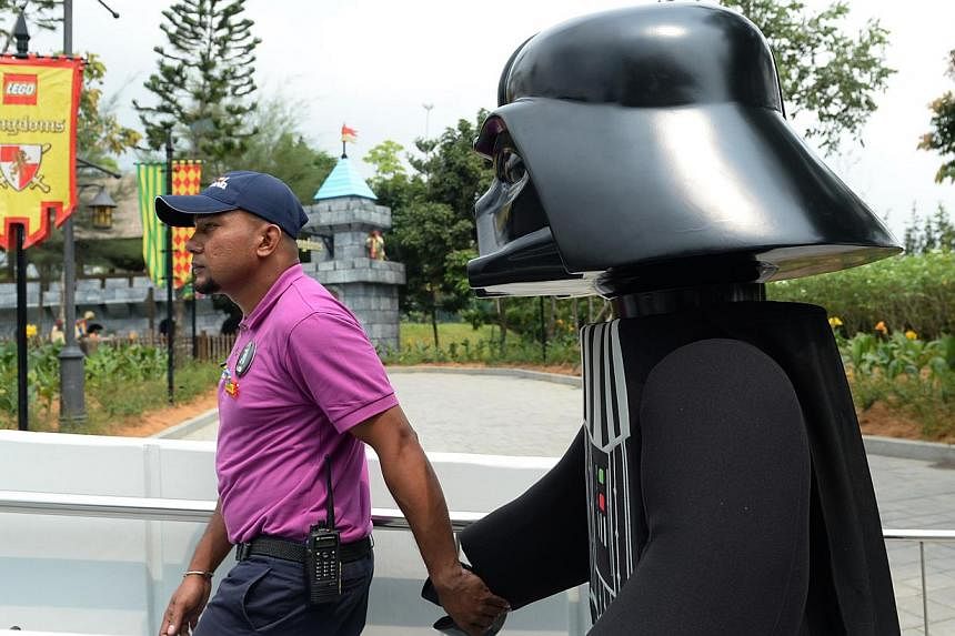 A Darth Vader 'minifig' is led by the hand before the launch of the Lego Star Wars Miniland on Sept 3, 2014. The new miniland will open to the public on September 6 at Legoland, Malaysia.&nbsp;&nbsp;-- ST PHOTO: JOYCE FANG