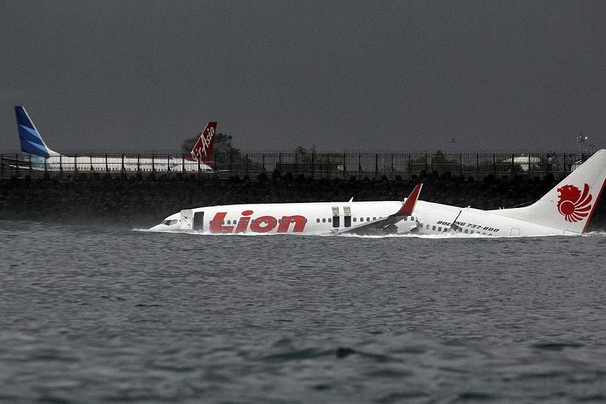 The body of a Lion Air plane is seen in the water after it missed the runway in Denpasar, Bali, in this file picture taken on April 13, 2013. Pilot errors, inadequate crew training and lapses in emergency response procedures led to the plane operated