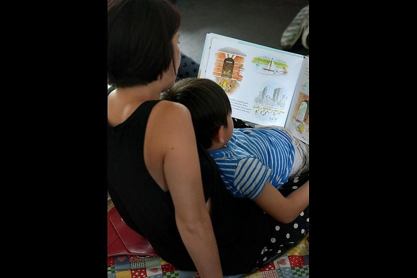 A mother reading And Tango Makes Three, a book NLB had pulled, to her child at a reading event.