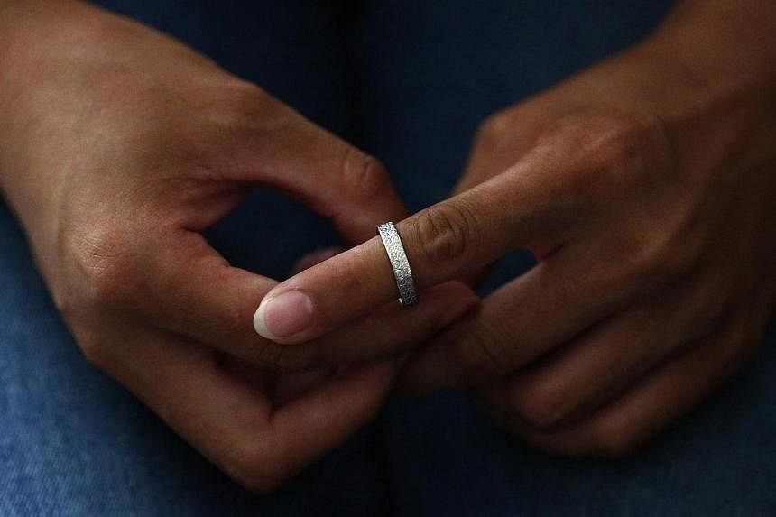 Liu, whose husband Li Zhijin was onboard Malaysia Airlines Flight MH370, tries her husband's ring on her finger in Beijing on July 22, 2014. -- PHOTO: REUTERS