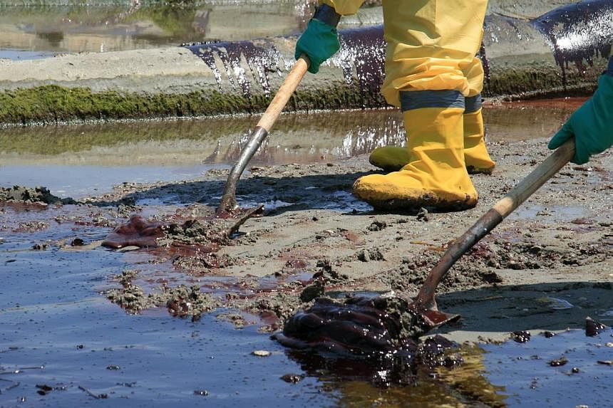 A BP cleanup crew shovels oil from a beach in this May 24, 2010, file photo, at Port Fourchon, Louisiana.&nbsp;BP potentially faces billions of dollars in new fines after a New Orleans judge concluded it acted with "gross negligence" ahead of the mas