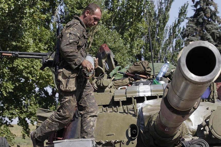 &nbsp;A Ukrainian serviceman loads a shell onto a tank at a checkpoint in the coastal town of Mariupol on Sept 5, 2014. -- PHOTO: REUTERS