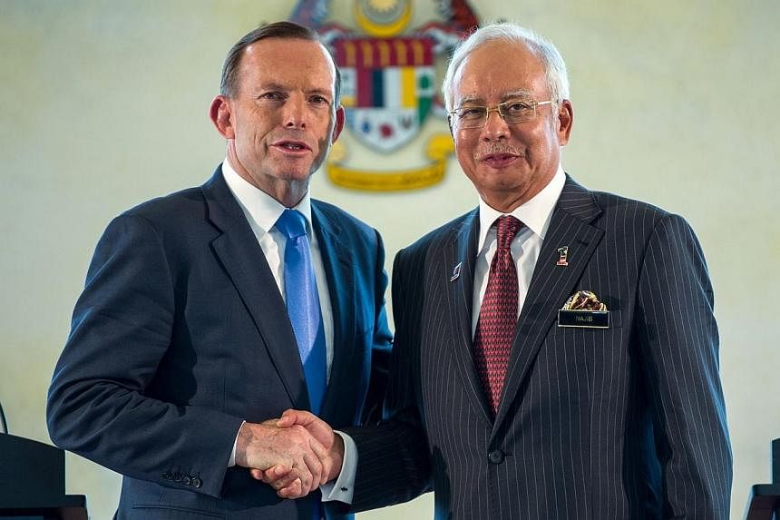 Malaysia's Prime Minister Najib Razak (right) shakes hands with his Australian counterpart Tony Abbott after a joint press conference at the prime minister's office in Putrajaya, outside Kuala Lumpur on Saturday, Sept 6, 2014.&nbsp;The search for Mal