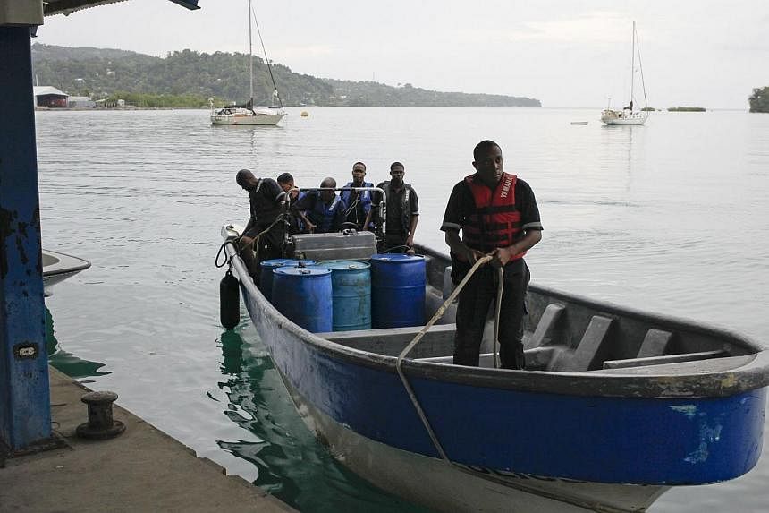 Members of Jamaica's Marine Police return to port after leaving the site where it is presumed a small US private plane with an unresponsive pilot crashed off the east coast of Jamaica, in Port Antonio on Sept 5, 2014. -- PHOTO: REUTERS