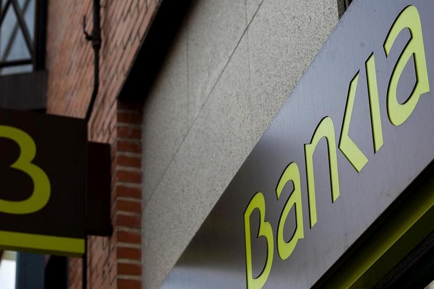 A logo sits on display outside a Bankia SA bank branch in Madrid, Spain, on Friday, Jan 10, 2014.&nbsp;Spanish banks will seek around 30 billion euros (S$48.7 billion) in loans from the European Central Bank’s programme to spur lending to businesse