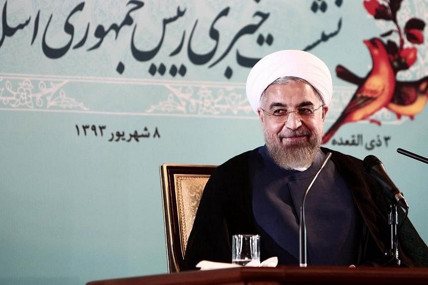 Iranian President Hassan Rouhani smiles during a press conference in Tehran on Aug 30, 2014. -- PHOTO: AFP