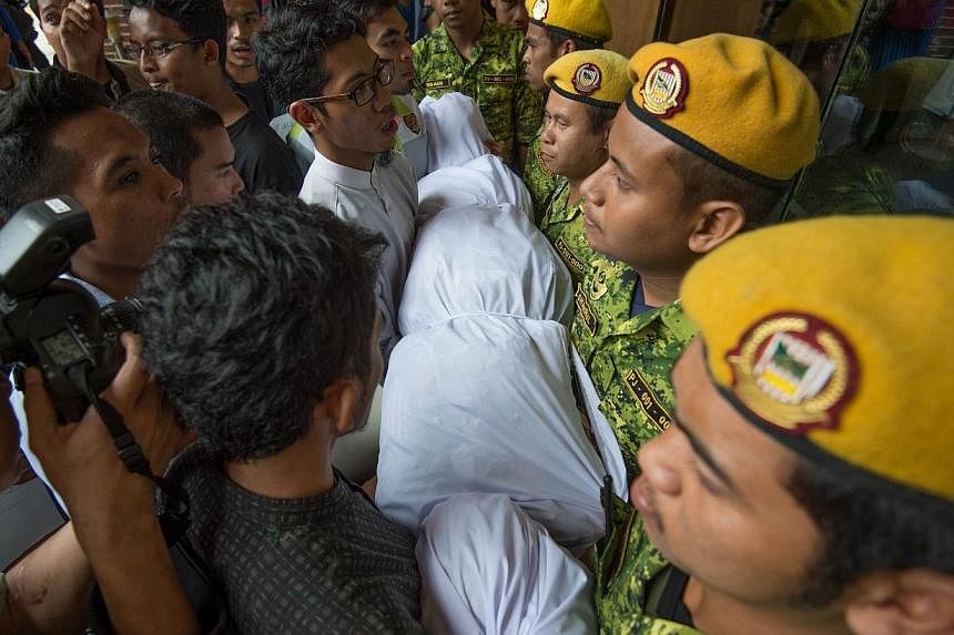 Malaysian students (left) carry a mock dead body during a protest against the sedition law outside the Ministry of Home Affairs building in Putrajaya, outside Kuala Lumpur on Sept 5, 2014. -- PHOTO: AFP