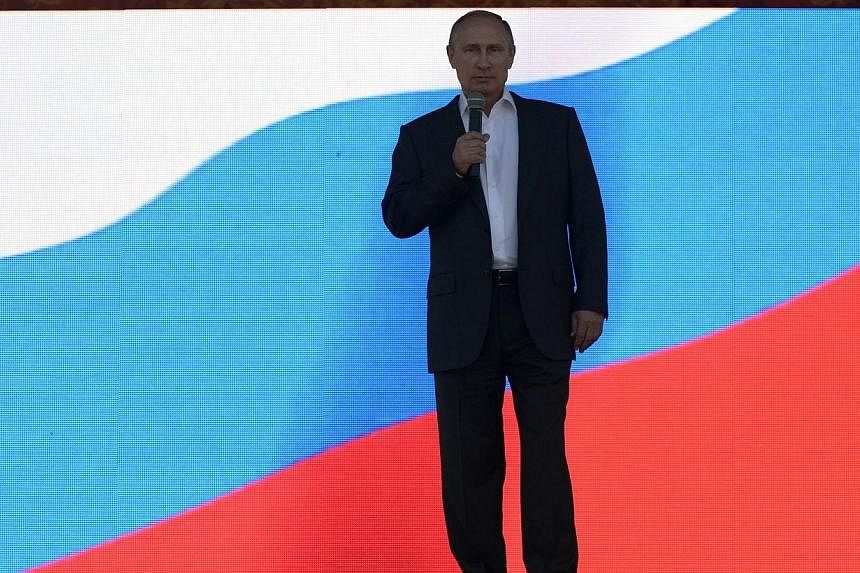 Russian President Vladimir Putin delivers a speech before the show dedicated to the 100th anniversary of the Republic of Tyva's joining Russia, at the Khuresh stadium in the city of Kyzyl on Sept 6, 2014. -- PHOTO: AFP
