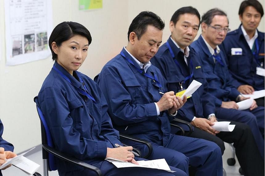 Newly appointed Japanese Economy, Trade and Industry Minister Yuko Obuchi (left) meets with workers of the tsunami-crippled Tokyo Electric Power Co.'s Fukushima Daiichi Nuclear Power Plant while vising the plant in Okuma, Fukushima Prefecture, northe