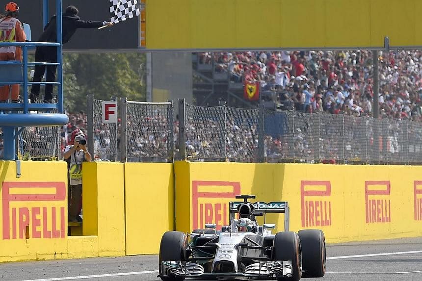 Mercedes' British driver Lewis Hamilton celebrates winning the Italian Formula One Grand Prix motor race at the Autodromo Nazionale circuit in Monza on Sept 7, 2014.&nbsp;-- PHOTO: AFP