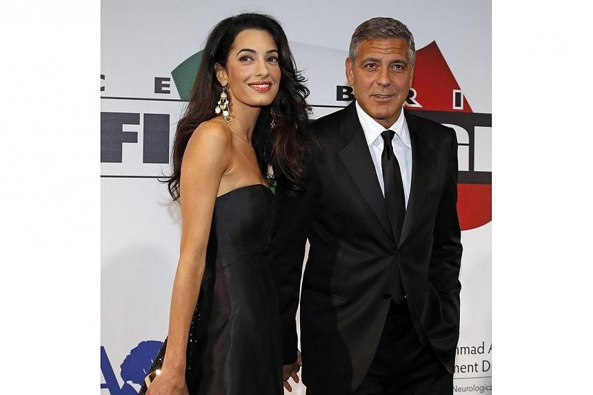 Director and actor George Clooney arrives with his fiancee, barrister Amal Alamuddin, to attend the Celebrity Fight Night event in Florence on Sunday, Sept 7, 2014, in their first public appearance together. -- PHOTO: REUTERS