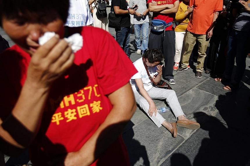 Family members of passengers onboard the missing Malaysia Airlines Flight MH370, cry as they gather to pray at Yonghegong Lama Temple in Beijing on Sept 8, 2014, on the six-month anniversary of the disappearance of the plane. -- PHOTO: REUTERS