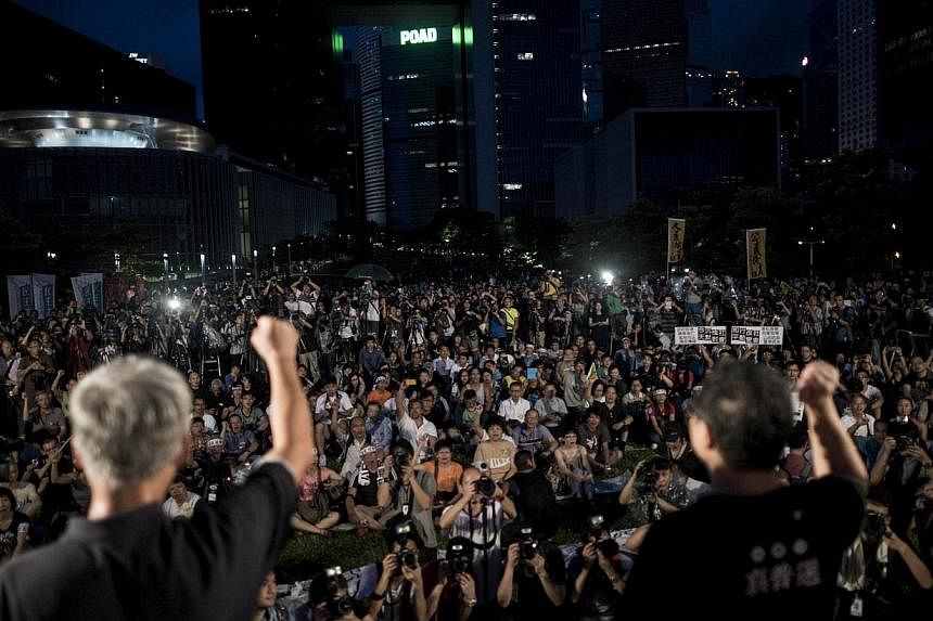 In this file picture taken on August 31, 2014, Benny Tai (right) and Chu You Ming (left), co-founders of the Occupy Central movement, rally with democracy activists next to the Hong Kong government complex.&nbsp;Ratings agency Moody's said on Monday,