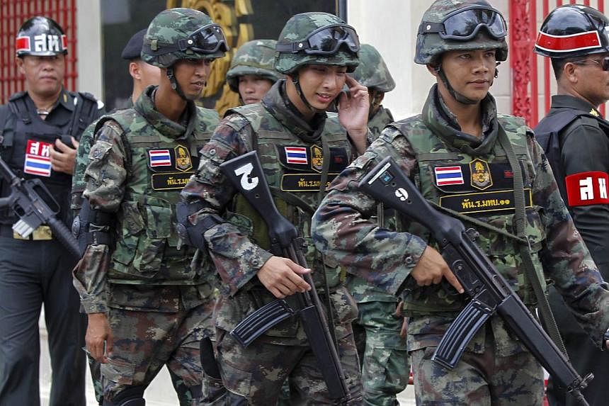 Soldiers patrol around the Royal Thai Army Headquarters as members of the Radio and Satellite Broadcasters gather in Bangkok on June 18, 2014.&nbsp;Rights activists on Monday renewed calls for an end to martial law imposed since Thailand's coup, accu