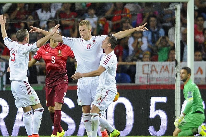 Albania's forward Bekim Balaj (centre) celebrates after scoring a goal during the UEFA EURO 2016 Qualifier football match Portugal vs Albania at the Municipal Stadium in Aveiro on Sept 7, 2014. -- PHOTO: AFP