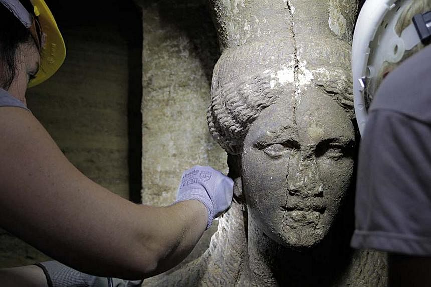This handout picture released by the Greek Ministry of Culture on Sept 7, 2014 shows one of the two statues of a Caryatid inside the Kasta Tumulus in ancient Amphipolis, northern Greece. -- PHOTO: AFP