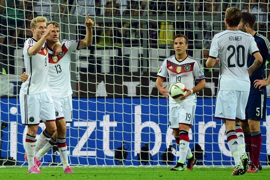 Germany's midfielder Thomas Mueller (second, left) celebrates with his teammates Germany's midfielder Andre Schuerrle (left), Germany's forward Mario Goetze (centre, with the ball) and Germany's midfielder Christoph Kramer (second, right) after scori