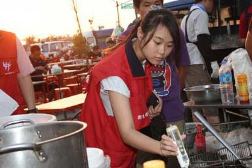 A staff member from the Public Health Bureau of Hsinchu County government in Taiwan uses inspection equipment to check oil used in a night market. Hong Kong is conducting food tests now as fears mount that Taiwan's gutter oil scandal could have sprea