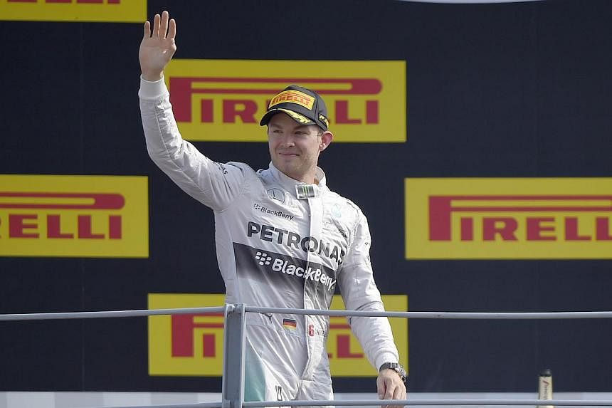 Second placed Mercedes' German driver Nico Rosberg waves as he arrives on the podium after the Italian Formula One Grand Prix motor race at the Autodromo Nazionale circuit in Monza on Sept 7, 2014. -- PHOTO: AFP
