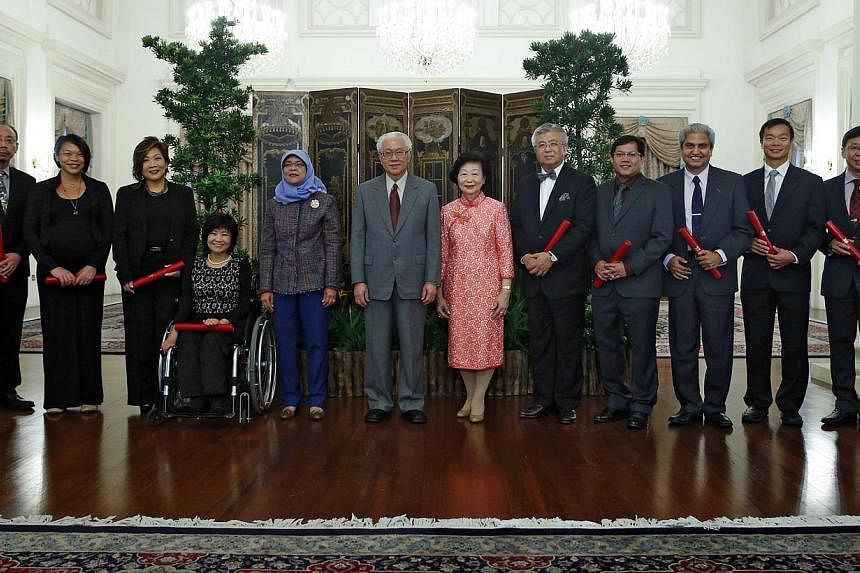 President Tony Tan Keng Yam (in grey suit) and his wife Mary (in red), and Speaker of Parliament Halimah Yacob (fifth from left) at the appointment ceremony of the Nominated Members of Parliament at the Istana on Aug 26, 2014. -- PHOTO: ST FILE