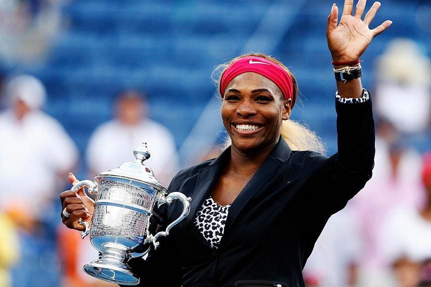 Serena Williams of the United States celebrates with the trophy after defeating Caroline Wozniacki of Denmark to win their women's singles final match on Day fourteen of the 2014 US Open at the USTA Billie Jean King National Tennis Center in the Flus