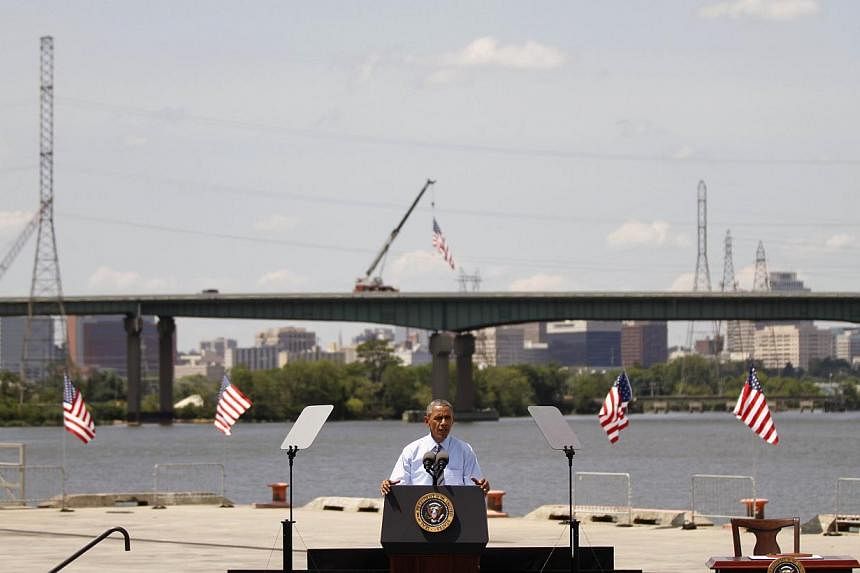 US President Barack Obama announcing a new national infrastructure initiative at the Port of Wilmington, Delaware, in front of the I-495 Bridge, which is undergoing substantial structural repairs on July 17, 2014. -- PHOTO: AFP